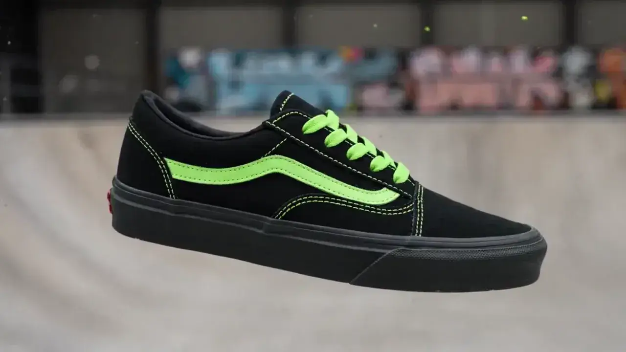 A white sneaker spinning in mid-air as neon green paint bursts across it