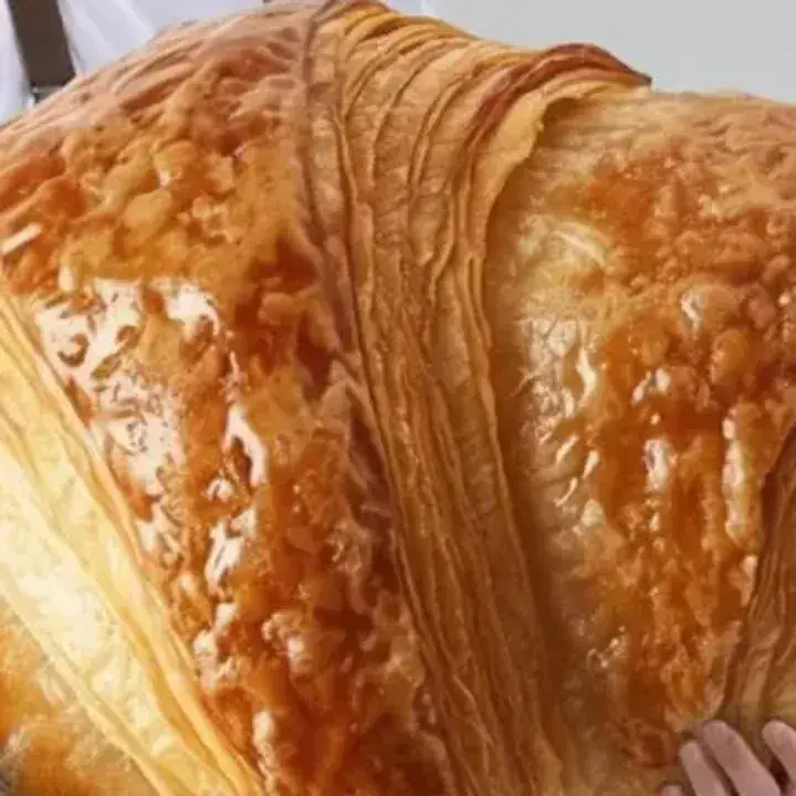 Product reference: the oversized golden croissant, isolated from the studio still